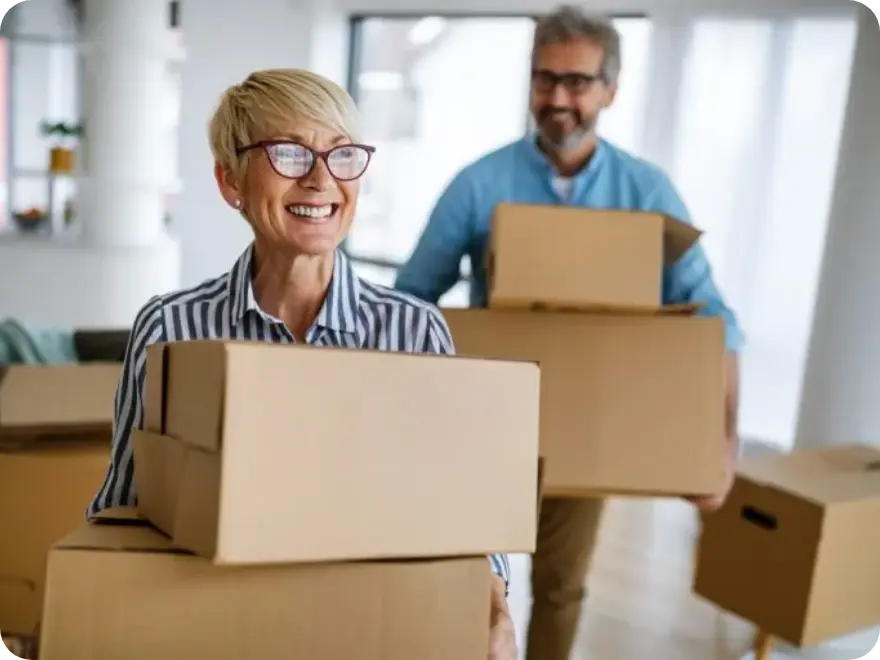 Two smiling people hold boxes.