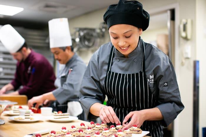 A Mirabella chef puts final touches on a plate of dessert.