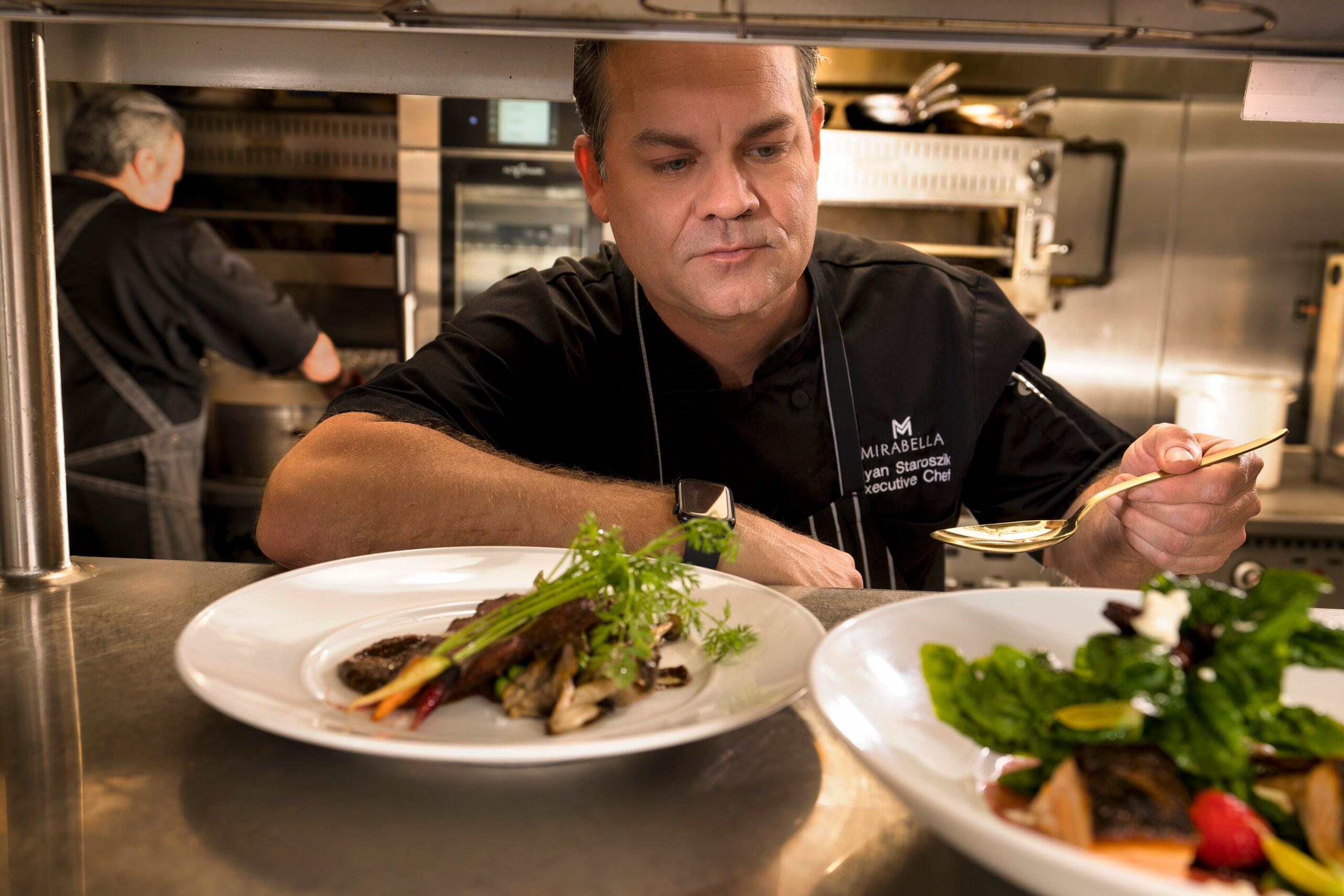 Mirabella Executive Chef pours a garnish over a dish.